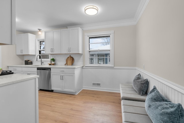 kitchen featuring sink, stainless steel dishwasher, white cabinets, and light wood-type flooring