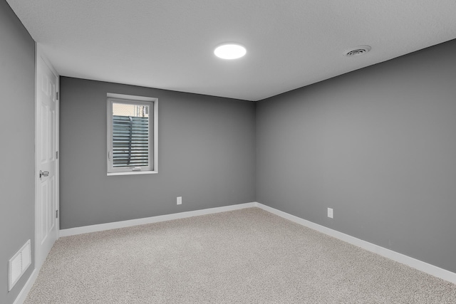 spare room with a textured ceiling and carpet flooring