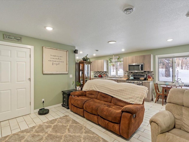 living room with light tile patterned floors, a textured ceiling, and a wealth of natural light