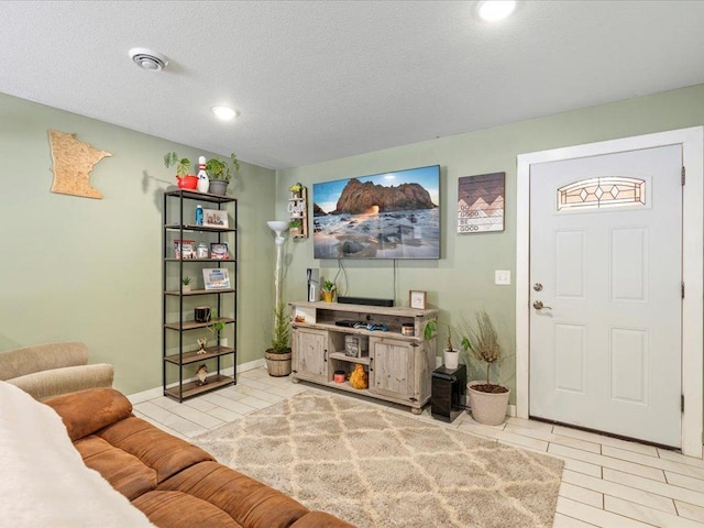 living room with light tile patterned flooring and a textured ceiling