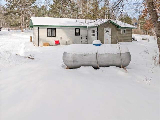 view of snow covered rear of property