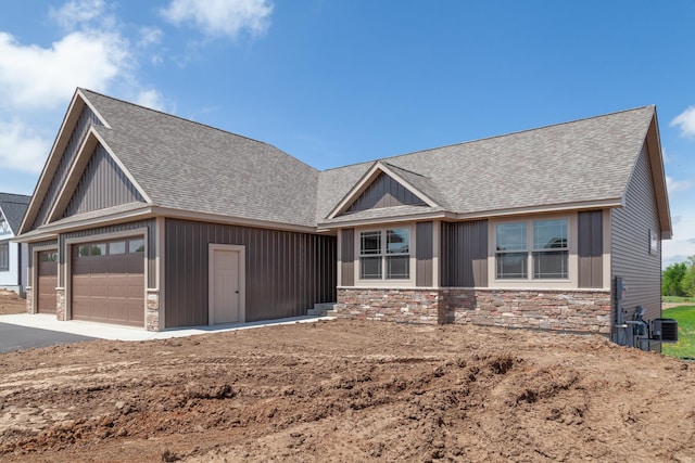 craftsman-style home featuring a garage and central AC unit