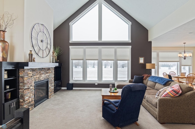 carpeted living room featuring an inviting chandelier, a fireplace, and high vaulted ceiling