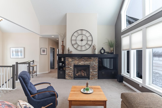 living room featuring light carpet, a stone fireplace, and high vaulted ceiling