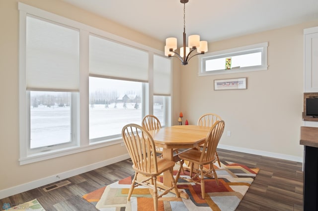 dining area featuring dark wood-type flooring and a notable chandelier