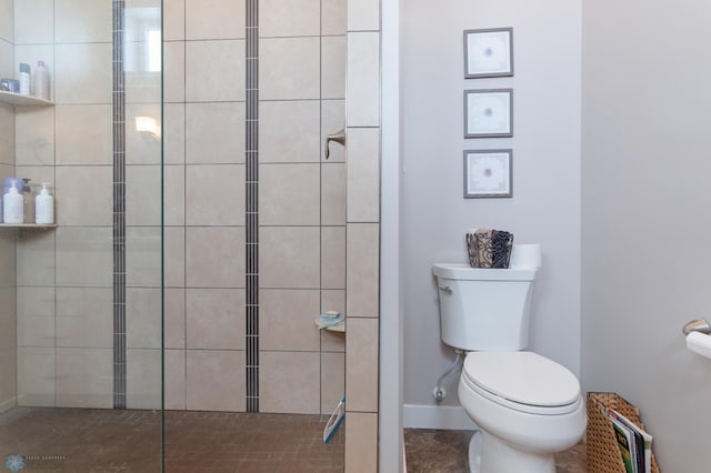 bathroom featuring a tile shower and toilet