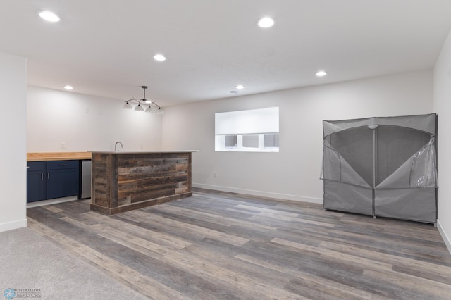 interior space with fridge, dark wood-type flooring, pendant lighting, and wood counters