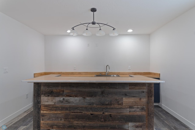 bar featuring sink, dark wood-type flooring, and pendant lighting