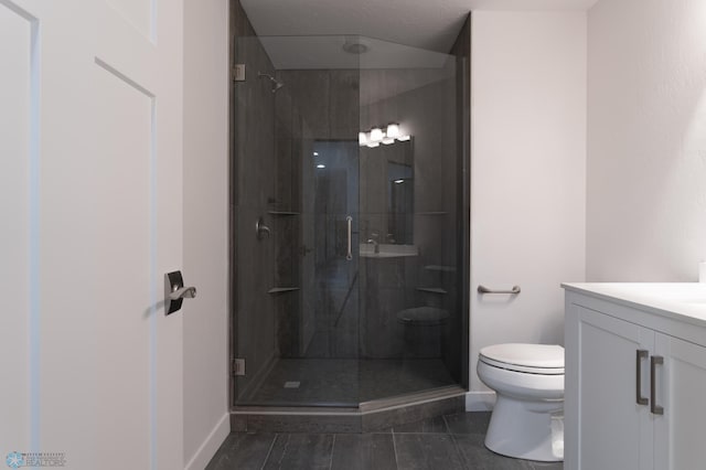 bathroom with vanity, tile patterned floors, a shower with door, and toilet