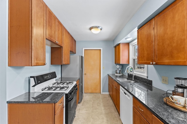 kitchen featuring sink, black range with gas stovetop, white dishwasher, and dark stone counters