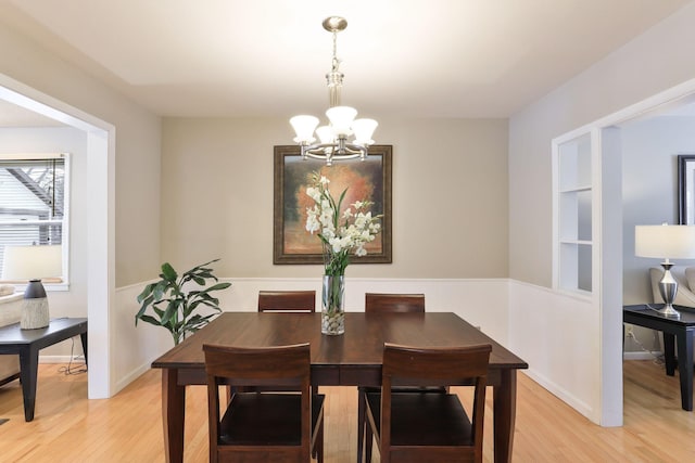 dining space with an inviting chandelier and light hardwood / wood-style floors