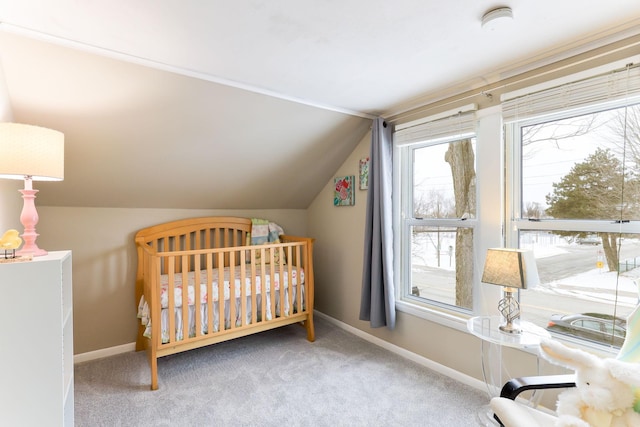 carpeted bedroom featuring a crib and lofted ceiling