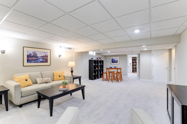 carpeted living room with a paneled ceiling