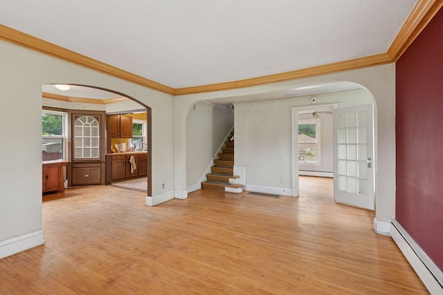 5801 23rd Ave S, Minneapolis, MN 55417 - unfurnished living room featuring a baseboard heating unit, arched walkways, crown molding, light wood-type flooring, and stairs