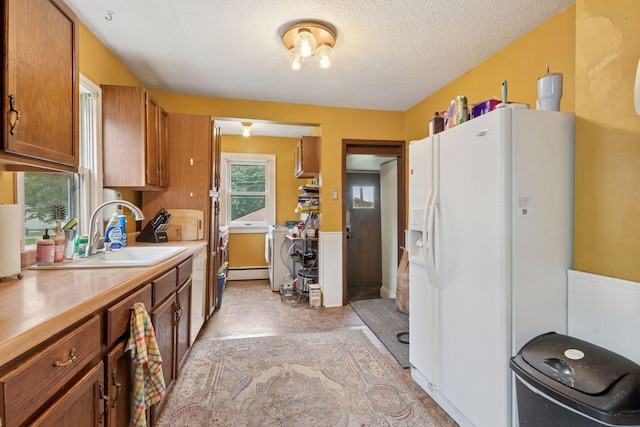 5801 23rd Ave S, Minneapolis, MN 55417 - kitchen with white fridge with ice dispenser, brown cabinets, light countertops, a textured ceiling, and a baseboard radiator