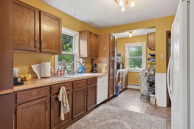 5801 23rd Ave S, Minneapolis, MN 55417 - kitchen featuring white appliances, light countertops, baseboard heating, and brown cabinetry