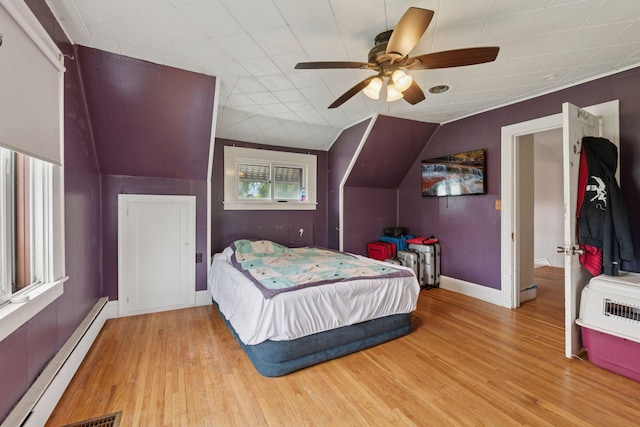 5801 23rd Ave S, Minneapolis, MN 55417 - bedroom featuring a baseboard heating unit, wood finished floors, a ceiling fan, and vaulted ceiling