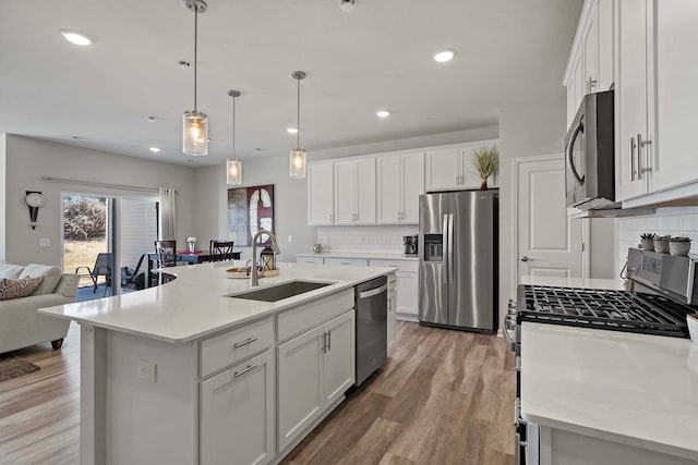 4884 Avery Ct, Eagan, MN 55123 - kitchen featuring appliances with stainless steel finishes, a sink, tasteful backsplash, open floor plan, and white cabinets
