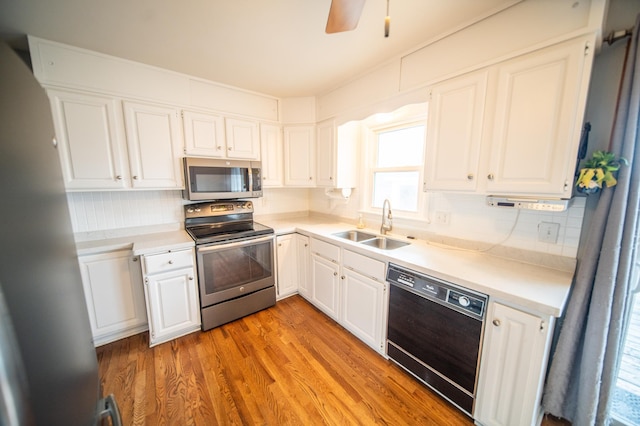 kitchen with sink, light hardwood / wood-style flooring, white cabinetry, stainless steel appliances, and tasteful backsplash