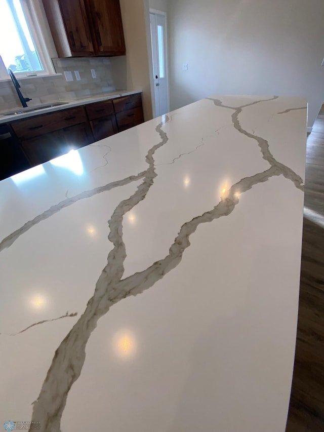 interior details with tasteful backsplash, sink, and light stone counters