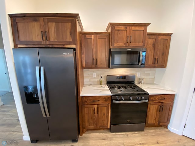 kitchen featuring tasteful backsplash, stainless steel appliances, and light hardwood / wood-style floors