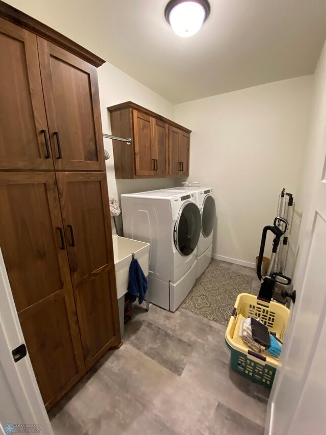 clothes washing area featuring cabinets and independent washer and dryer