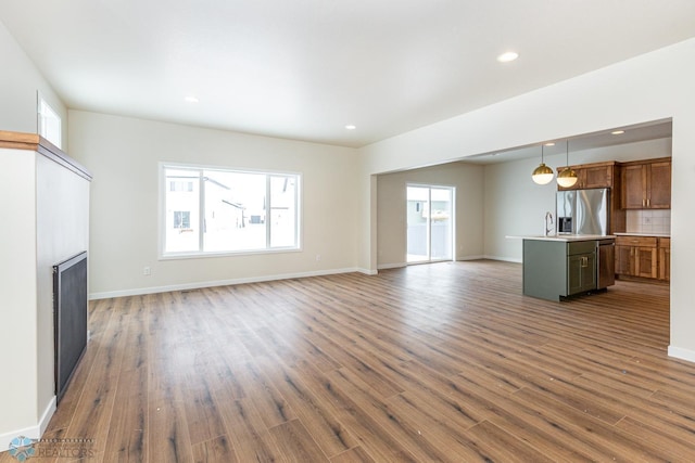 5476 Lori Ln W, West Fargo, ND 58078 - unfurnished living room featuring healthy amount of natural light, dark wood-type flooring, a fireplace, and recessed lighting