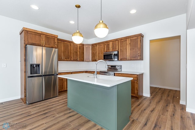 5476 Lori Ln W, West Fargo, ND 58078 - kitchen with appliances with stainless steel finishes, wood finished floors, light countertops, a sink, and decorative light fixtures