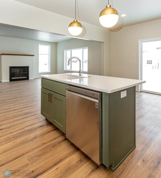 5476 Lori Ln W, West Fargo, ND 58078 - kitchen with stainless steel dishwasher, a sink, light wood-style floors, an island with sink, and light countertops