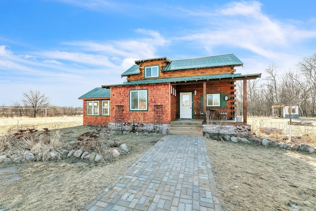 log cabin featuring covered porch and metal roof