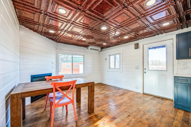 dining space featuring recessed lighting, light wood-style flooring, an ornate ceiling, and a wall mounted air conditioner