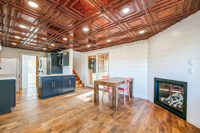 interior space featuring blue cabinetry, an ornate ceiling, light wood-style floors, a fireplace, and light countertops