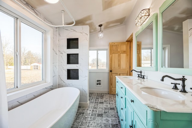 full bathroom with a freestanding bath, double vanity, heating unit, and a sink