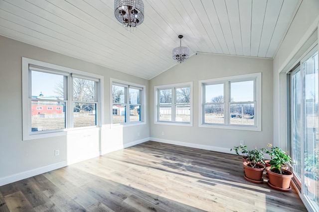 unfurnished sunroom featuring plenty of natural light, lofted ceiling, and an inviting chandelier