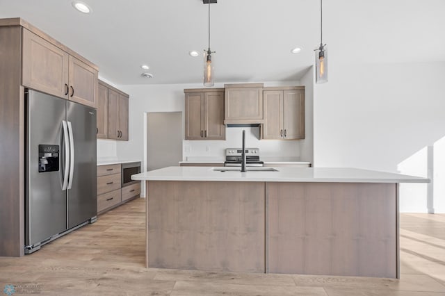 kitchen with pendant lighting, sink, light hardwood / wood-style floors, an island with sink, and stainless steel fridge with ice dispenser