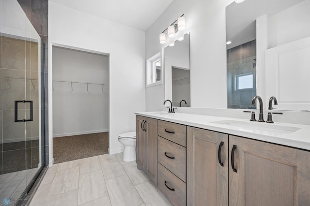 bathroom with vanity, toilet, and a shower with door