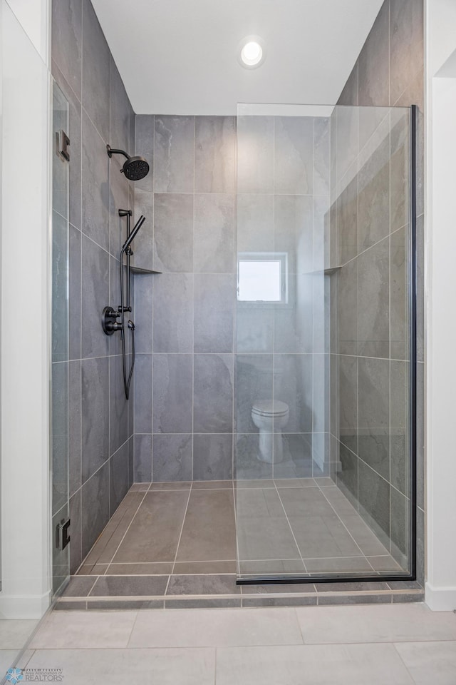 bathroom featuring toilet and tiled shower