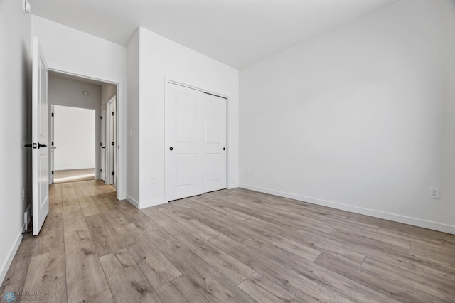 unfurnished bedroom featuring light hardwood / wood-style floors and a closet