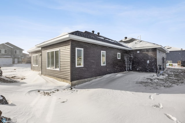 view of snow covered back of property