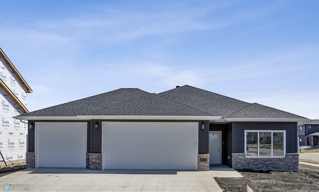 view of front of property with brick siding, roof with shingles, driveway, and a garage
