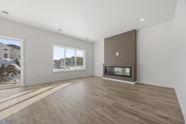 unfurnished living room with wood finished floors and baseboards