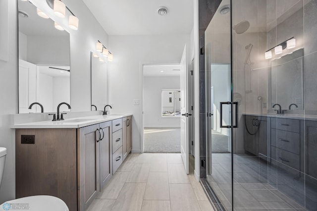full bath with a sink, a shower stall, and double vanity