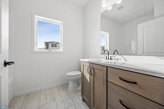 bathroom with visible vents, baseboards, vanity, and toilet