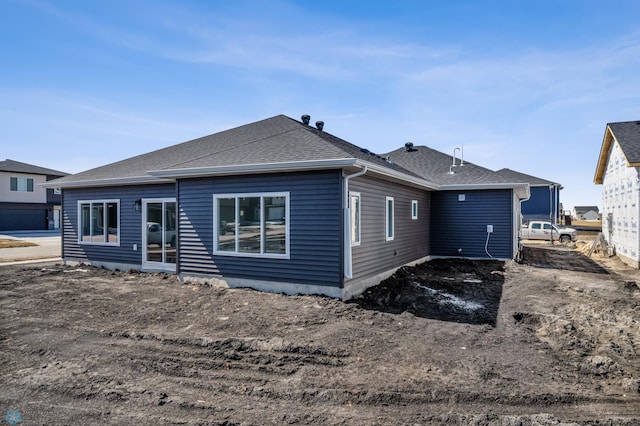back of property with a shingled roof