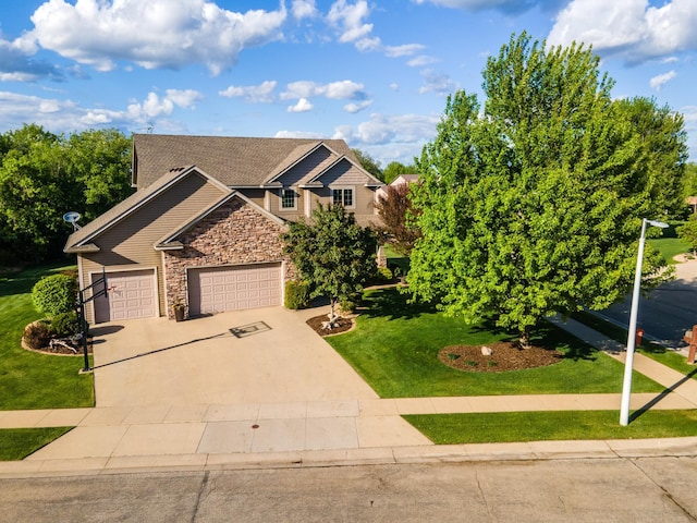 2441 Rosewood Ln SW, Rochester, MN 55902 - view of front of house with stone siding, concrete driveway, a front lawn, and a garage