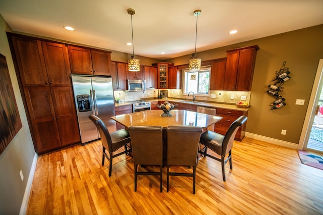 2441 Rosewood Ln SW, Rochester, MN 55902 - kitchen featuring appliances with stainless steel finishes, a sink, light wood finished floors, a breakfast bar, and recessed lighting