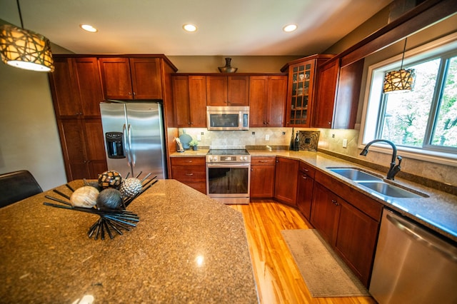 2441 Rosewood Ln SW, Rochester, MN 55902 - kitchen featuring appliances with stainless steel finishes, a sink, light wood-style flooring, glass insert cabinets, and recessed lighting