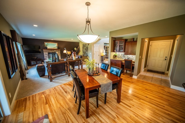 2441 Rosewood Ln SW, Rochester, MN 55902 - dining space with light wood finished floors, a glass covered fireplace, recessed lighting, and baseboards
