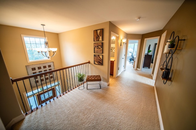 2441 Rosewood Ln SW, Rochester, MN 55902 - corridor with a chandelier, light carpet, and baseboards