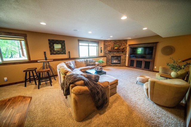 2441 Rosewood Ln SW, Rochester, MN 55902 - living area featuring carpet flooring, recessed lighting, a stone fireplace, baseboards, and a textured ceiling